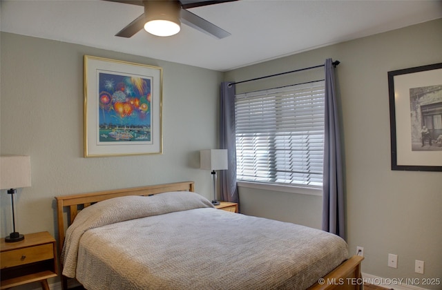 bedroom with a ceiling fan and baseboards