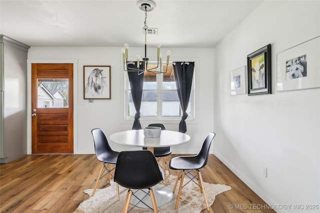 435781 E 130th Rd, Welch, OK 74369 - dining area with a chandelier, hardwood / wood-style flooring, and baseboards