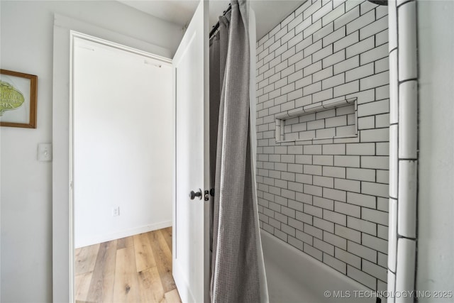 435781 E 130th Rd, Welch, OK 74369 - bathroom featuring wood finished floors, shower / tub combo with curtain, and baseboards