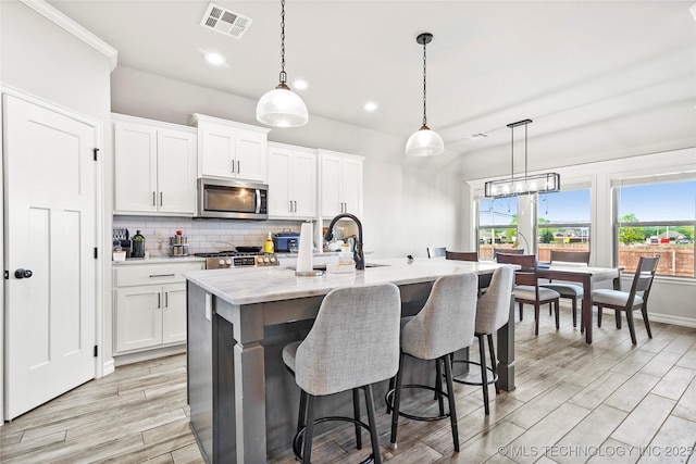 2661 S Catalayah Ln, Claremore, OK 74019 - kitchen with stainless steel microwave, decorative backsplash, a sink, white cabinets, and recessed lighting
