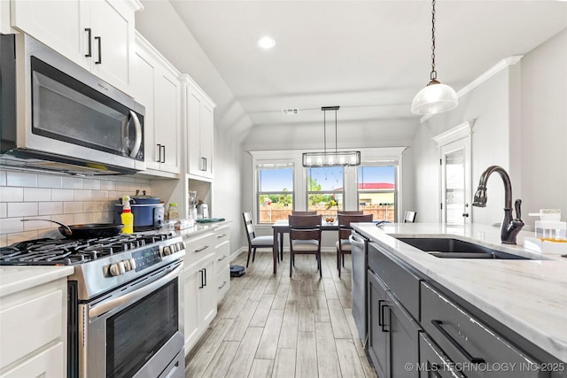 2661 S Catalayah Ln, Claremore, OK 74019 - kitchen featuring appliances with stainless steel finishes, a sink, backsplash, white cabinets, and light wood finished floors