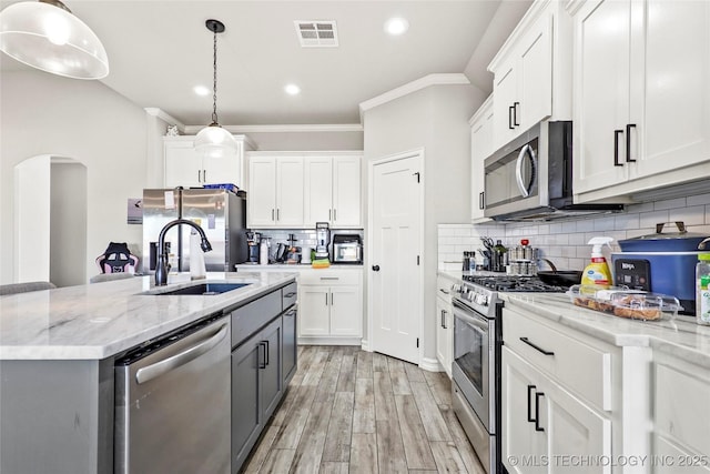 2661 S Catalayah Ln, Claremore, OK 74019 - kitchen with stainless steel appliances, a sink, crown molding, decorative backsplash, and white cabinets