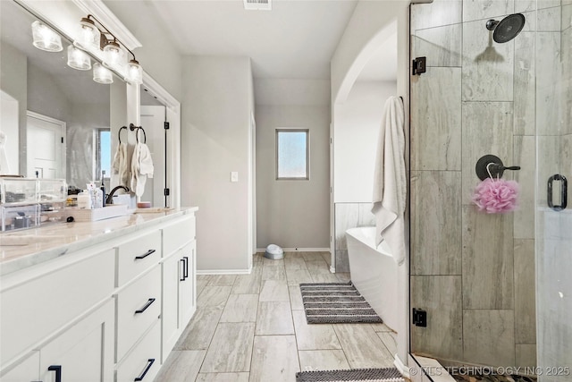 2661 S Catalayah Ln, Claremore, OK 74019 - full bath with a stall shower, double vanity, a freestanding bath, and baseboards