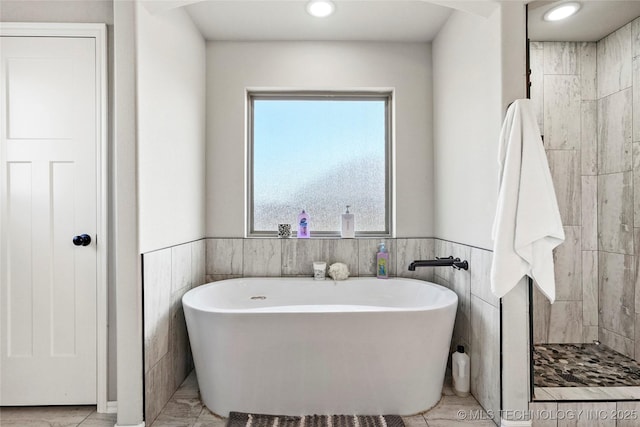 2661 S Catalayah Ln, Claremore, OK 74019 - bathroom featuring a freestanding bath, wainscoting, recessed lighting, and tile walls