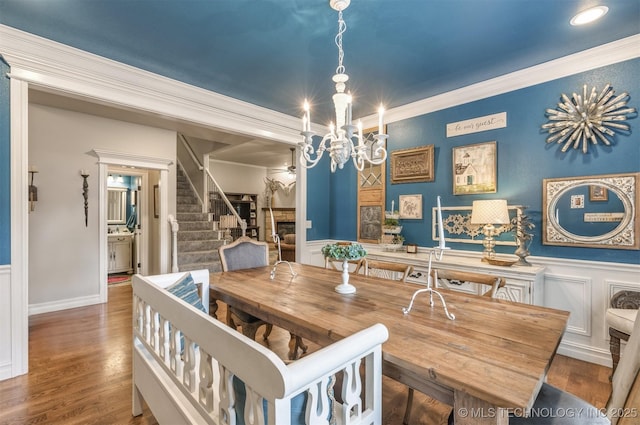7333 S 286th E Ave, Broken Arrow, OK 74014 - dining area with a chandelier, stairway, crown molding, a wainscoted wall, and wood finished floors
