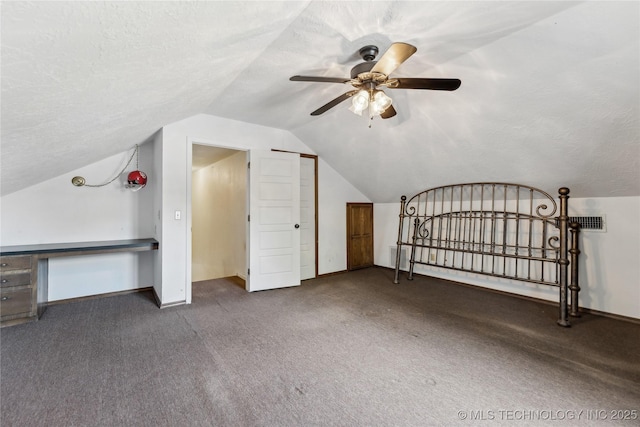 additional living space with vaulted ceiling, carpet flooring, baseboards, ceiling fan, and a textured ceiling