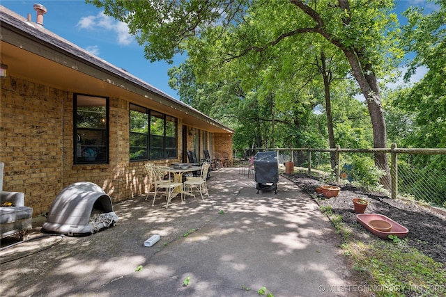 view of patio / terrace with outdoor dining area, a grill, and fence