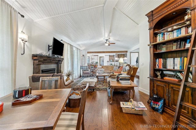 living area featuring lofted ceiling, a fireplace, a ceiling fan, hardwood / wood-style flooring, and baseboards