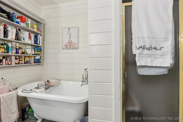bathroom featuring ornamental molding, a freestanding tub, and wooden walls