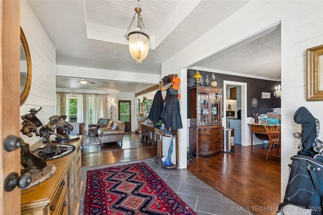 foyer entrance with a ceiling fan and a textured ceiling