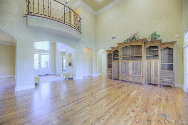 14832 S 53rd E Ave, Bixby, OK 74008 - unfurnished living room with arched walkways, wood-type flooring, a towering ceiling, baseboards, and ornamental molding