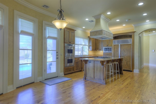 14832 S 53rd E Ave, Bixby, OK 74008 - kitchen with stainless steel appliances, light wood-type flooring, brown cabinets, ornamental molding, and recessed lighting