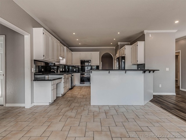 15412 E 78th St N, Owasso, OK 74055 - kitchen featuring stainless steel appliances, dark countertops, a peninsula, crown molding, and white cabinetry