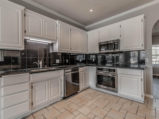 15412 E 78th St N, Owasso, OK 74055 - kitchen with stainless steel appliances, dark countertops, a sink, arched walkways, and crown molding