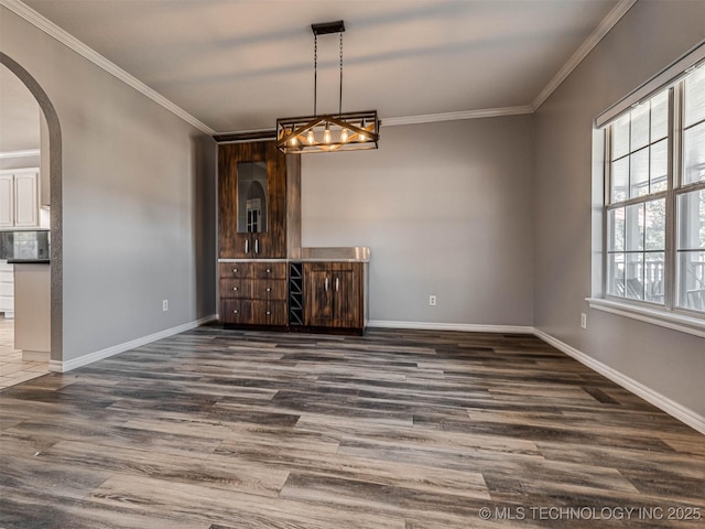 15412 E 78th St N, Owasso, OK 74055 - unfurnished dining area featuring arched walkways, crown molding, dark wood-style flooring, and baseboards