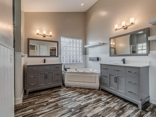 15412 E 78th St N, Owasso, OK 74055 - full bathroom featuring wood finished floors, wainscoting, two vanities, and a bath