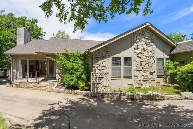 3901 E 60th Pl, Tulsa, OK 74135 - view of front of house with stone siding, a chimney, and roof with shingles