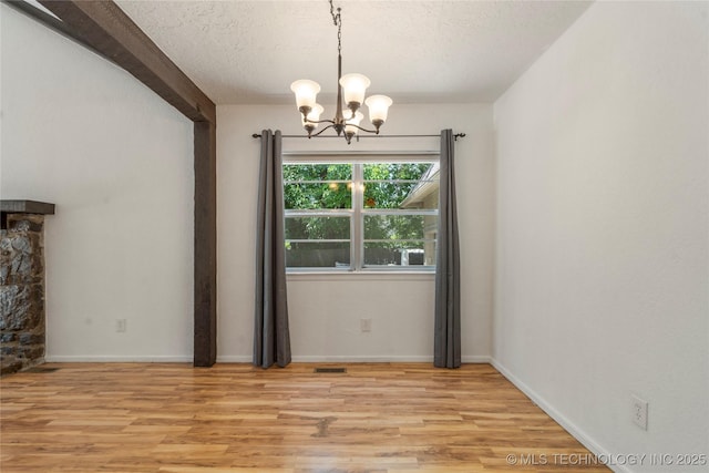 3901 E 60th Pl, Tulsa, OK 74135 - unfurnished dining area featuring a chandelier, light wood-style flooring, a textured ceiling, and baseboards