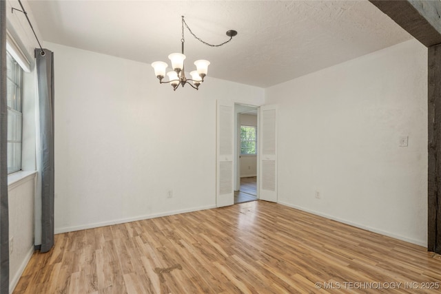 3901 E 60th Pl, Tulsa, OK 74135 - unfurnished room with light wood finished floors, a chandelier, and baseboards