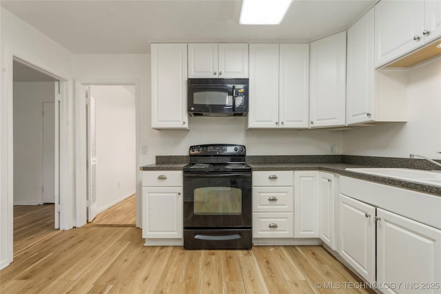 3901 E 60th Pl, Tulsa, OK 74135 - kitchen featuring black appliances, white cabinets, dark countertops, and light wood-style floors