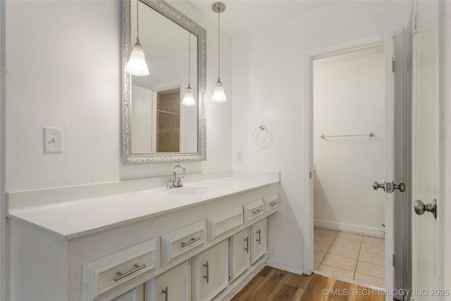 3901 E 60th Pl, Tulsa, OK 74135 - bathroom with vanity, baseboards, and wood finished floors
