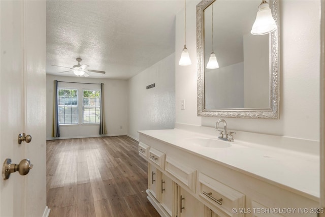 3901 E 60th Pl, Tulsa, OK 74135 - bathroom with a ceiling fan, wood finished floors, a textured ceiling, vanity, and baseboards