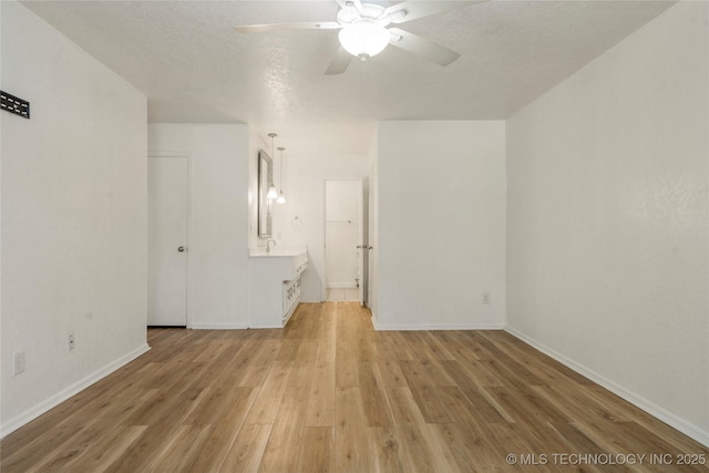 3901 E 60th Pl, Tulsa, OK 74135 - empty room with light wood finished floors, ceiling fan, baseboards, and a sink