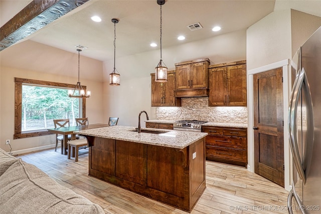 117683 Powell Rd, Eufaula, OK 74432 - kitchen featuring a sink, appliances with stainless steel finishes, tasteful backsplash, light stone counters, and light wood-type flooring