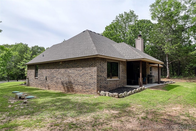 117683 Powell Rd, Eufaula, OK 74432 - view of side of home with a patio area, brick siding, a lawn, and a chimney