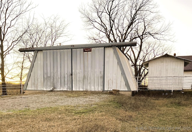 view of outdoor structure featuring fence and an outdoor structure