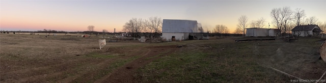 view of yard with a barn, an outdoor structure, and a view of countryside