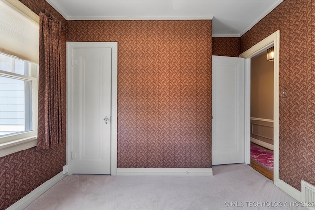 unfurnished bedroom with wallpapered walls, carpet flooring, and crown molding