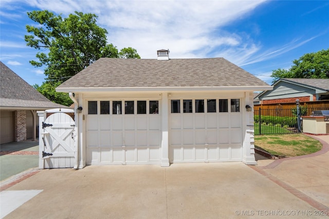 detached garage with fence and a gate