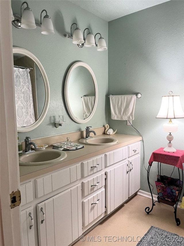 bathroom with double vanity and a textured ceiling