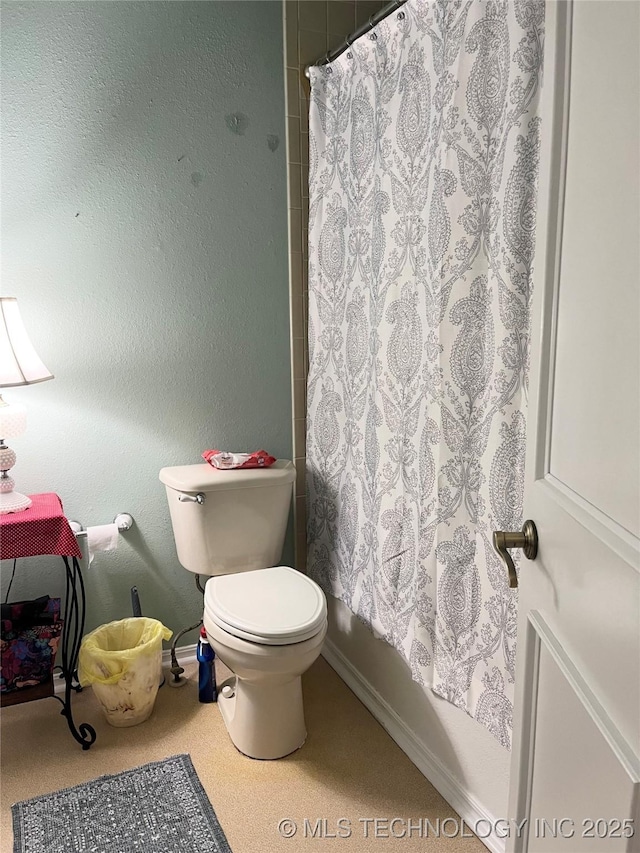 full bath featuring toilet and baseboards