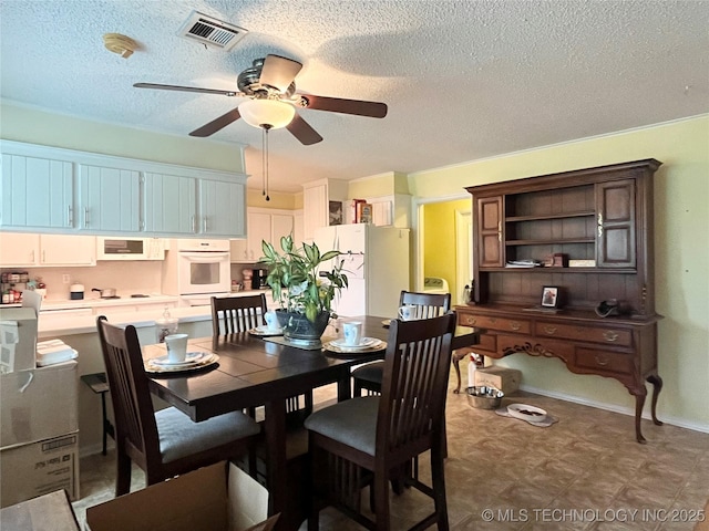 dining space featuring a ceiling fan and a textured ceiling