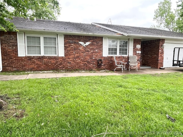 back of house featuring a lawn, brick siding, and roof with shingles