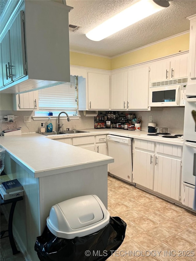 kitchen with white appliances, a textured ceiling, a sink, light countertops, and white cabinetry