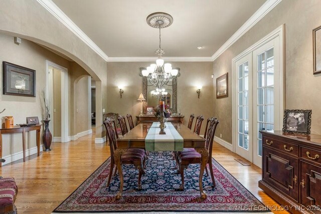 716 W 108th Pl S, Jenks, OK 74037 - dining space with arched walkways, light wood-style floors, a chandelier, ornamental molding, and baseboards