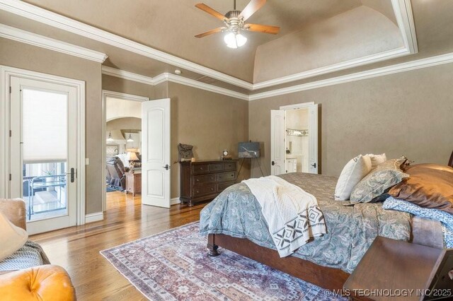 716 W 108th Pl S, Jenks, OK 74037 - bedroom featuring arched walkways, wood finished floors, a tray ceiling, ensuite bath, and ceiling fan