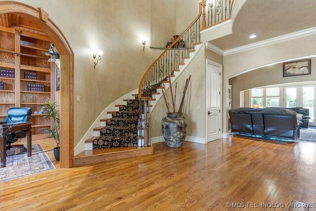716 W 108th Pl S, Jenks, OK 74037 - stairway featuring a high ceiling, crown molding, wood finished floors, baseboards, and arched walkways