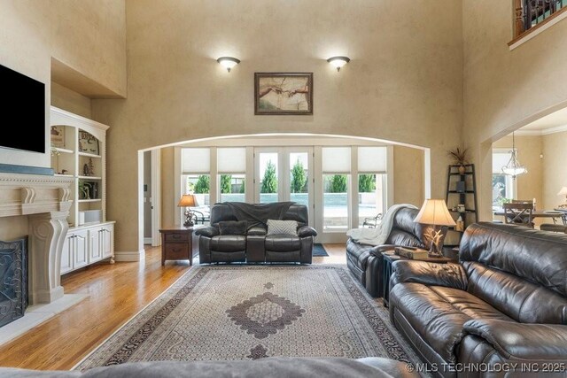 716 W 108th Pl S, Jenks, OK 74037 - living area with a high ceiling, plenty of natural light, wood finished floors, a chandelier, and a fireplace with raised hearth