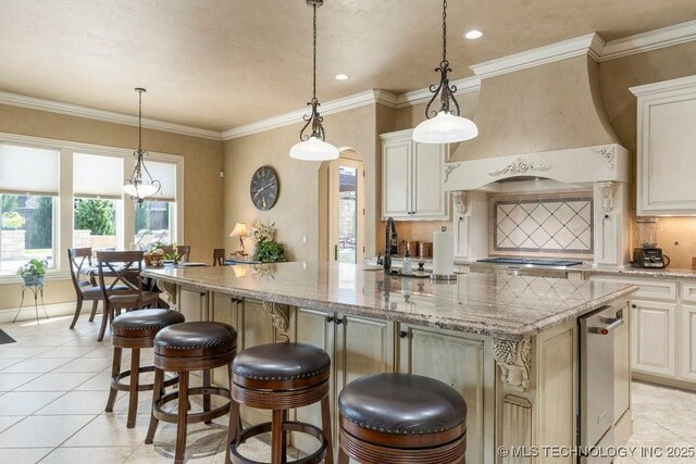 716 W 108th Pl S, Jenks, OK 74037 - kitchen with an island with sink, light tile patterned flooring, stainless steel gas stovetop, hanging light fixtures, and recessed lighting