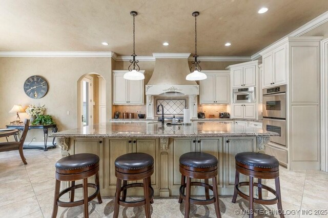 716 W 108th Pl S, Jenks, OK 74037 - kitchen with arched walkways, custom exhaust hood, double oven, a spacious island, and recessed lighting