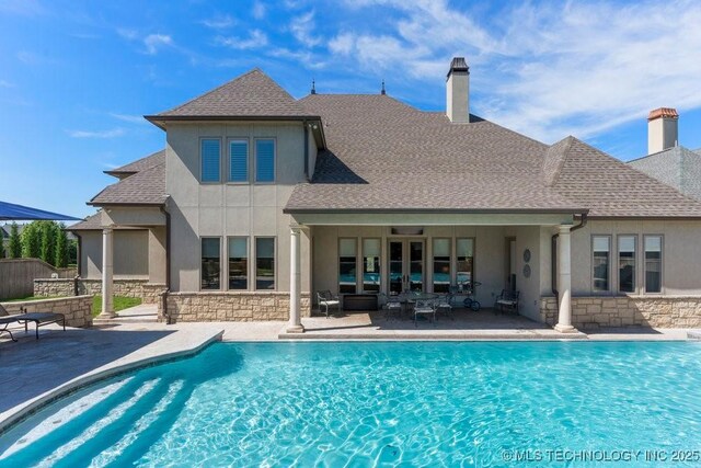 716 W 108th Pl S, Jenks, OK 74037 - rear view of house featuring stone siding, a chimney, and stucco siding