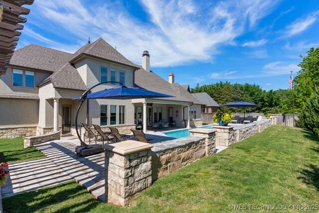 716 W 108th Pl S, Jenks, OK 74037 - rear view of house with stucco siding, a patio area, a jacuzzi, a shingled roof, and stone siding