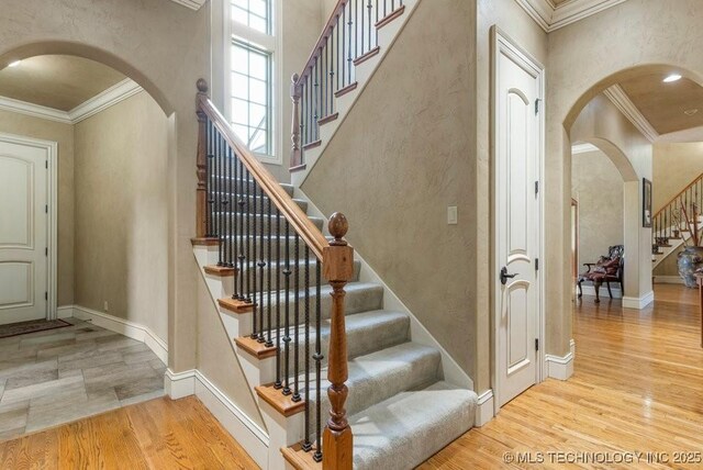 716 W 108th Pl S, Jenks, OK 74037 - stairway featuring arched walkways, ornamental molding, wood finished floors, baseboards, and a textured wall