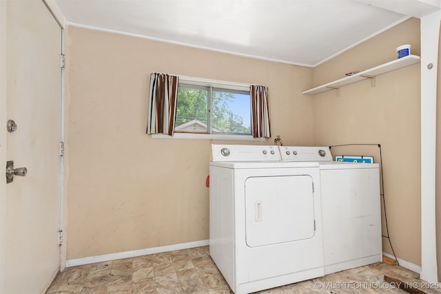 clothes washing area with washer and dryer and baseboards
