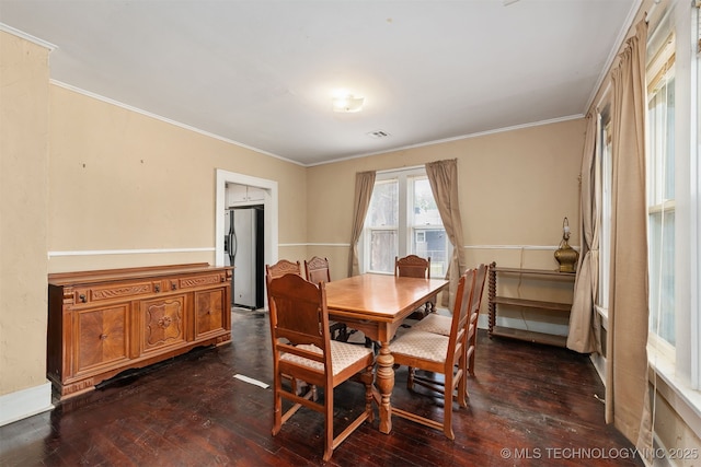 dining space with dark wood finished floors and crown molding