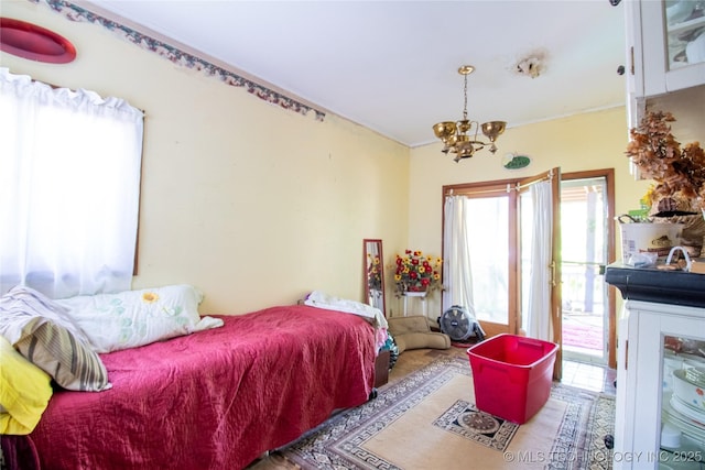 bedroom featuring a chandelier and access to outside